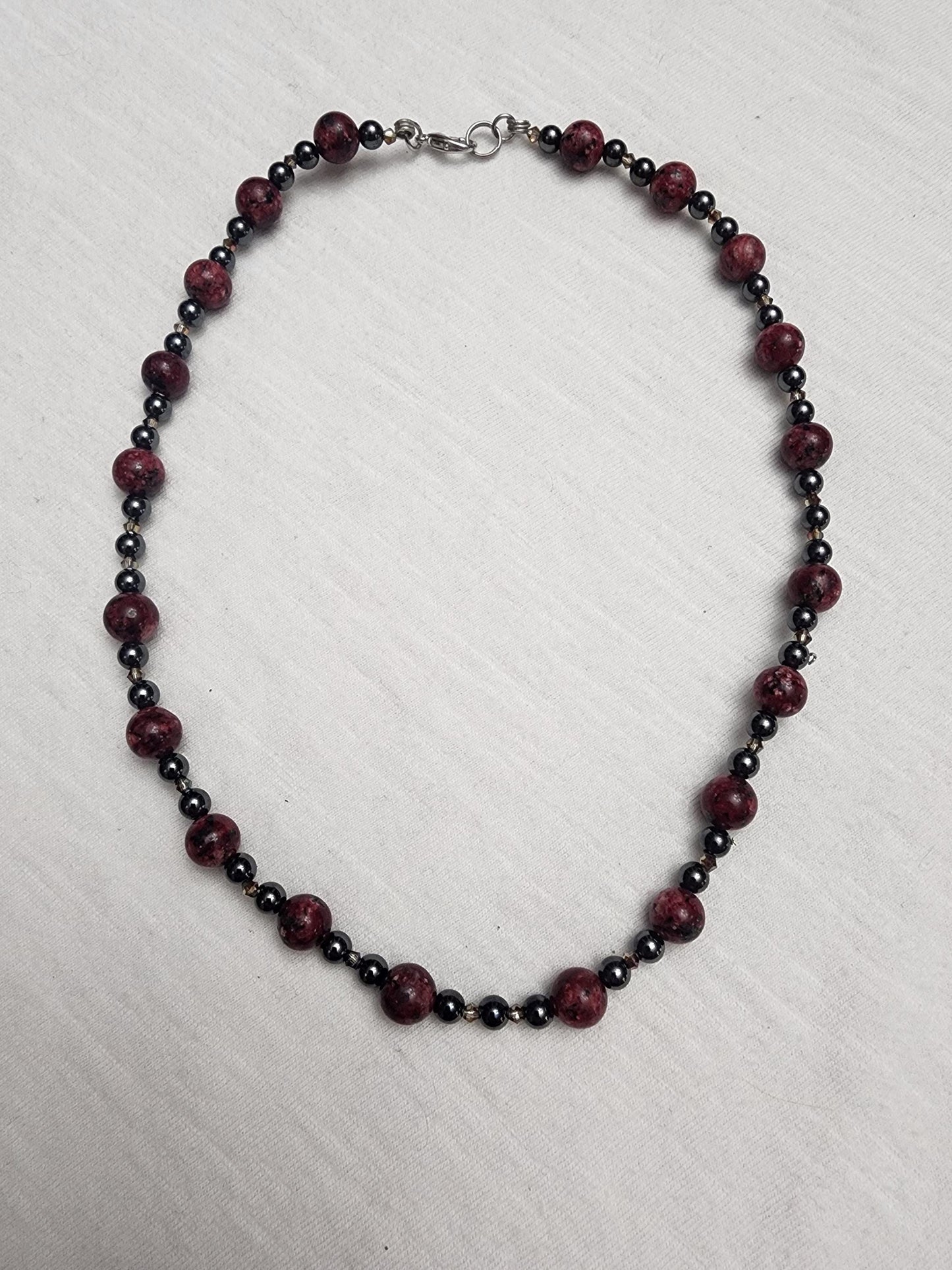 Red Jasper with Hematite and acrylic accents.