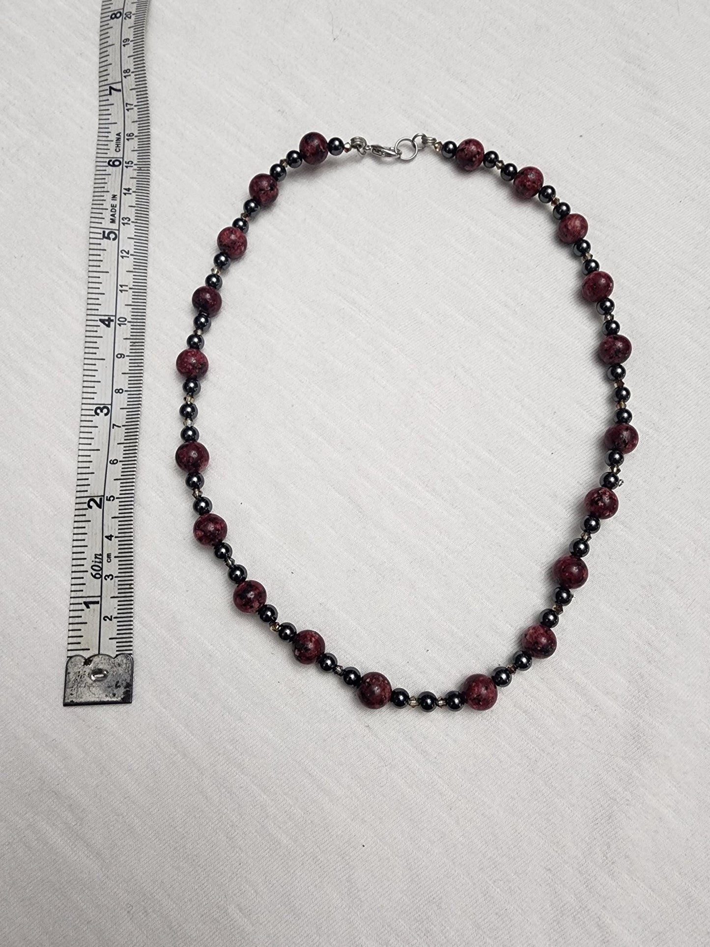 Red Jasper with Hematite and acrylic accents.