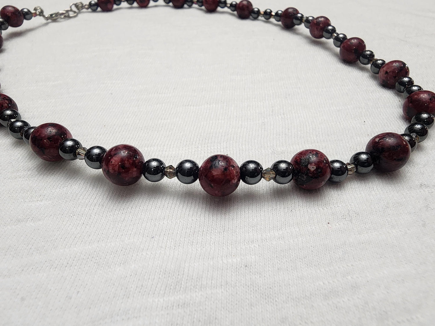 Red Jasper with Hematite and acrylic accents.